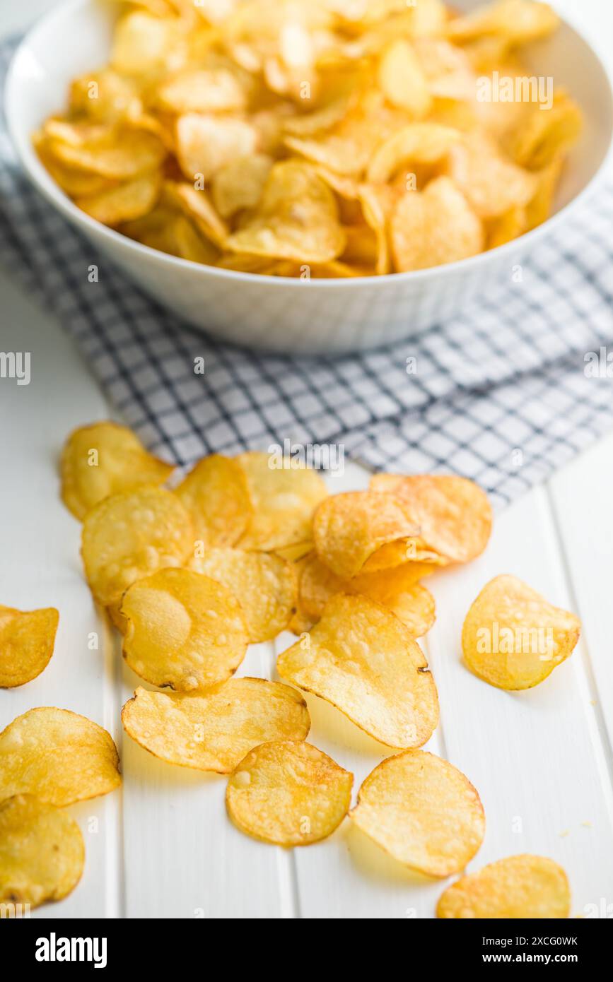 Crispy Potato Chips on a white table. Stock Photo