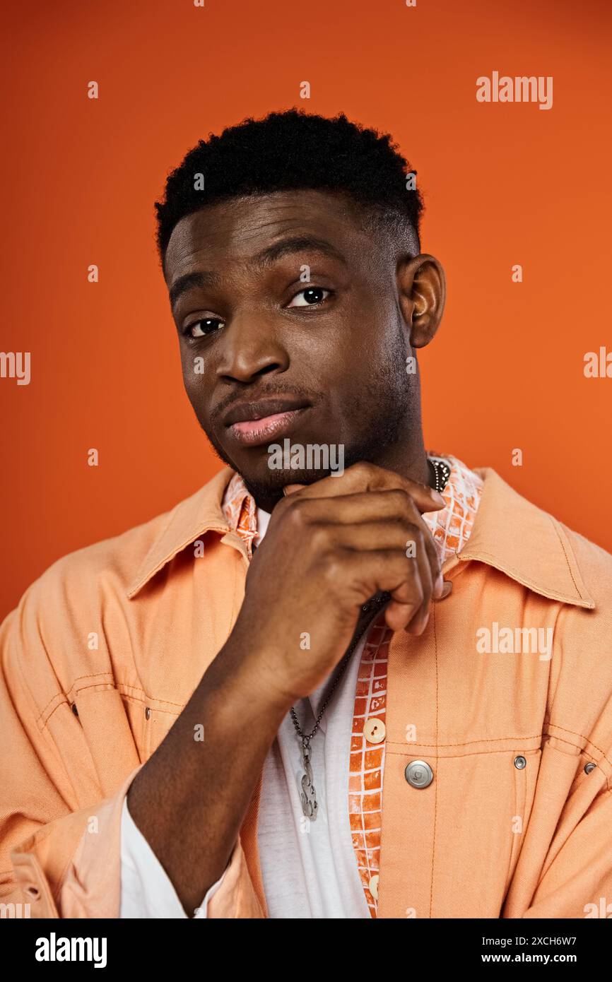 Stylish young man posing confidently in vibrant orange jacket Stock ...