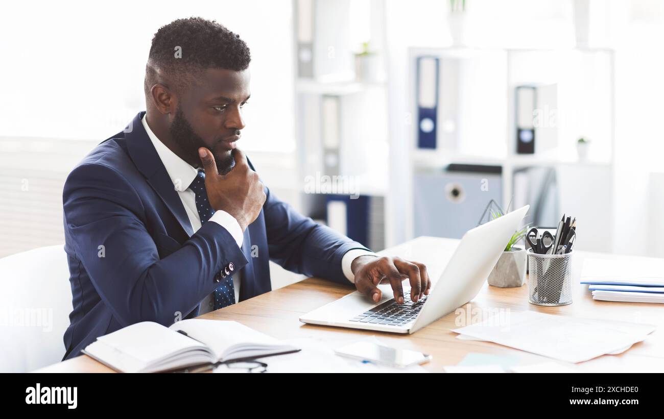 Young african american entrepreneur studying competitors online Stock Photo