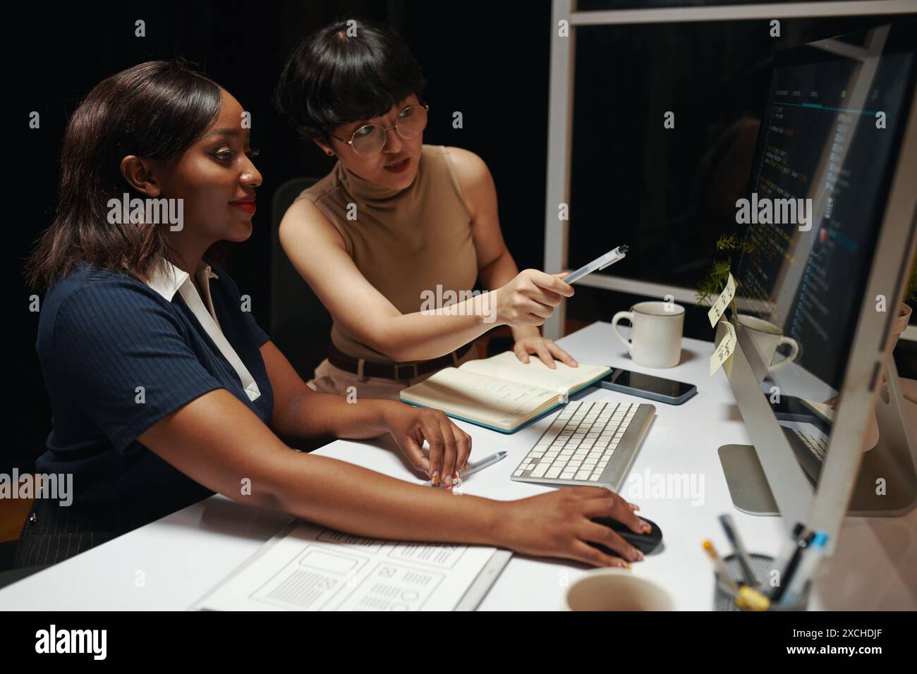 Positive colleagues working on programming code for mobile app Stock Photo