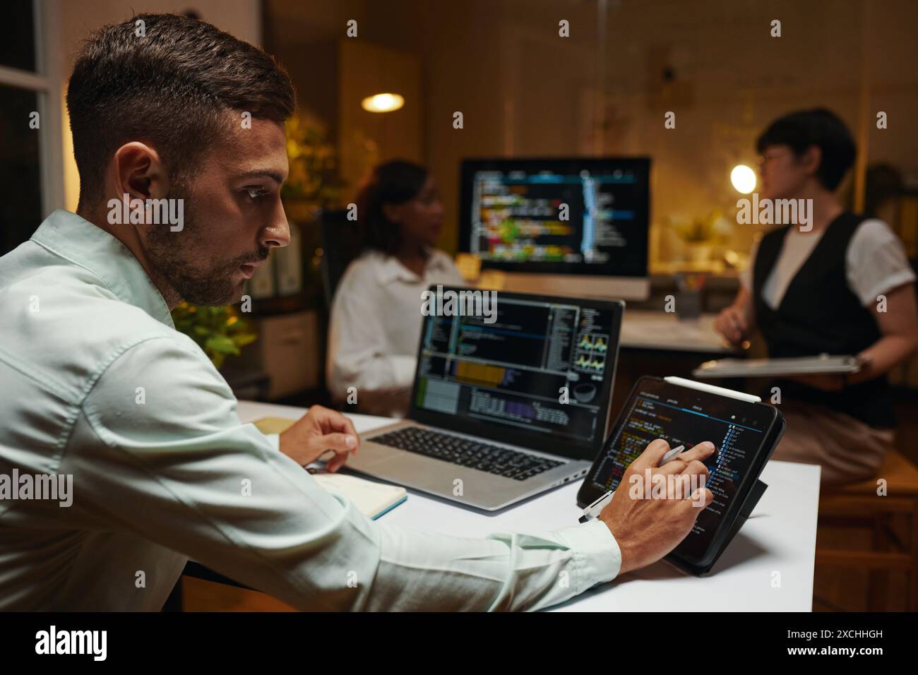 Developer checking programming code on tablet and laptop Stock Photo