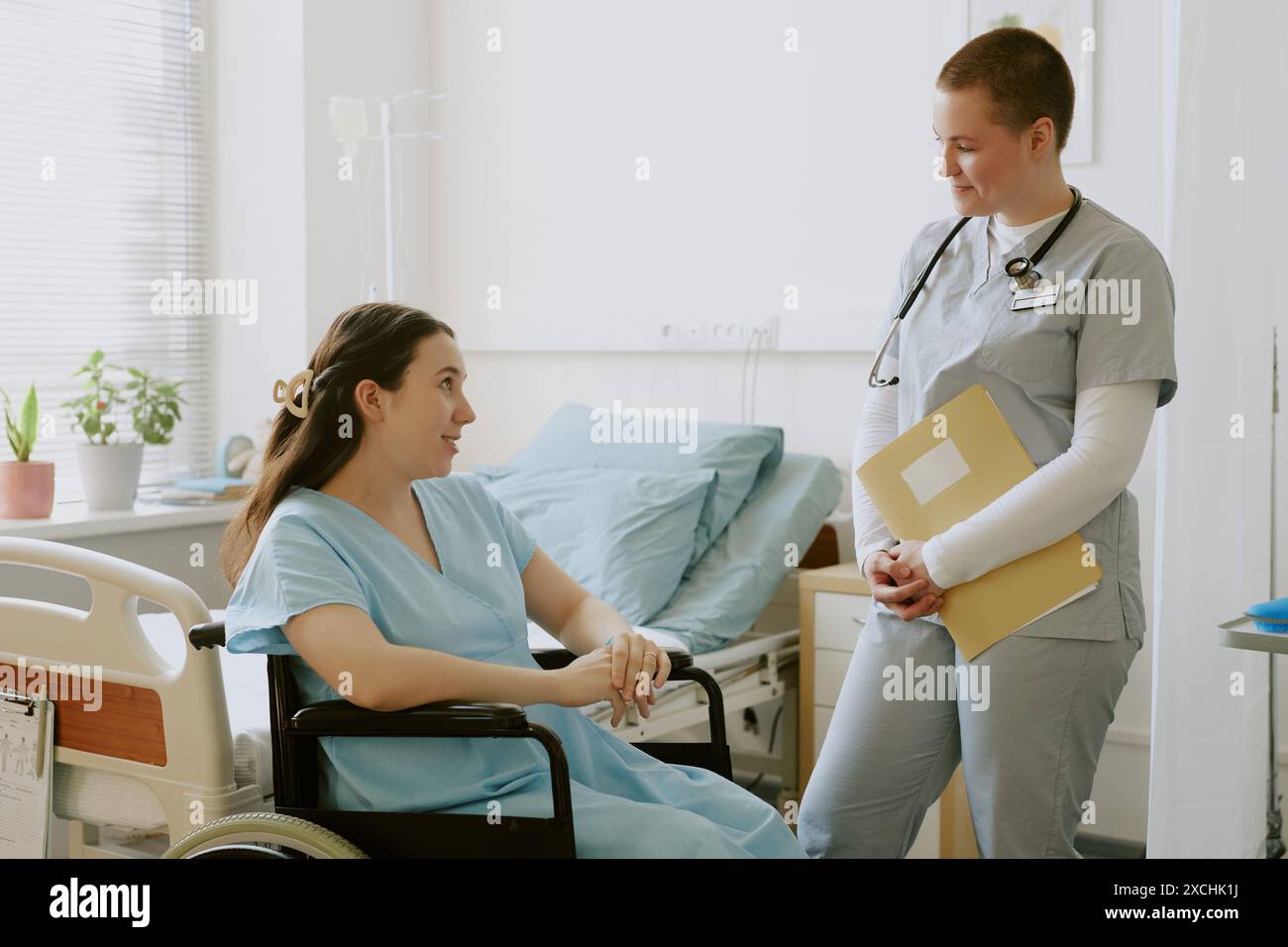 Sitting Labour Young nurse holding yellow folder and listening to young woman in labor ...