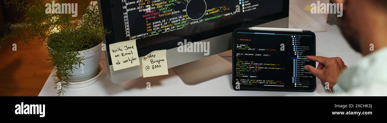 Web banner with programming code on screen of laptop and computer Stock Photo
