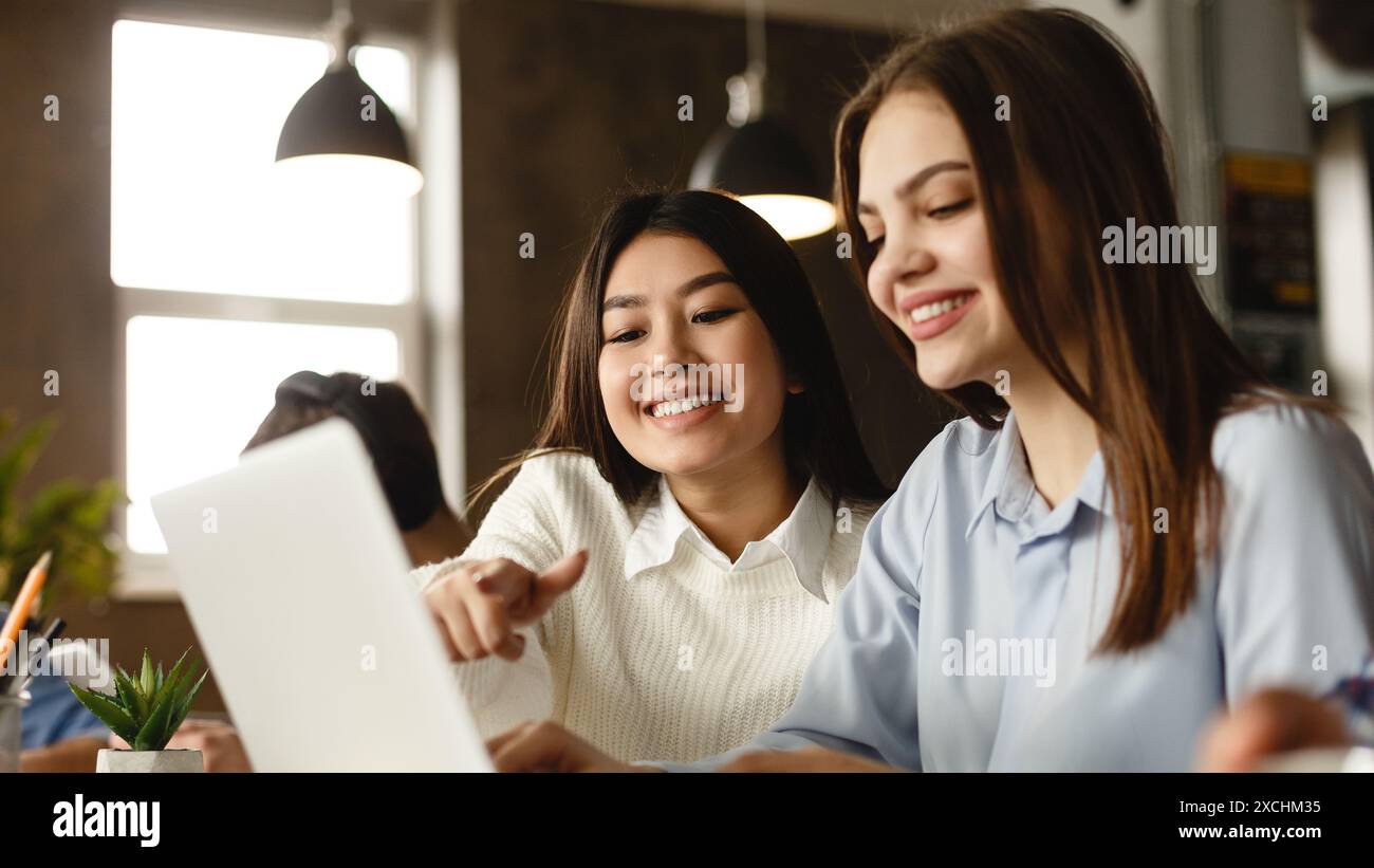 Education concept. Happy students with laptop in library Stock Photo ...