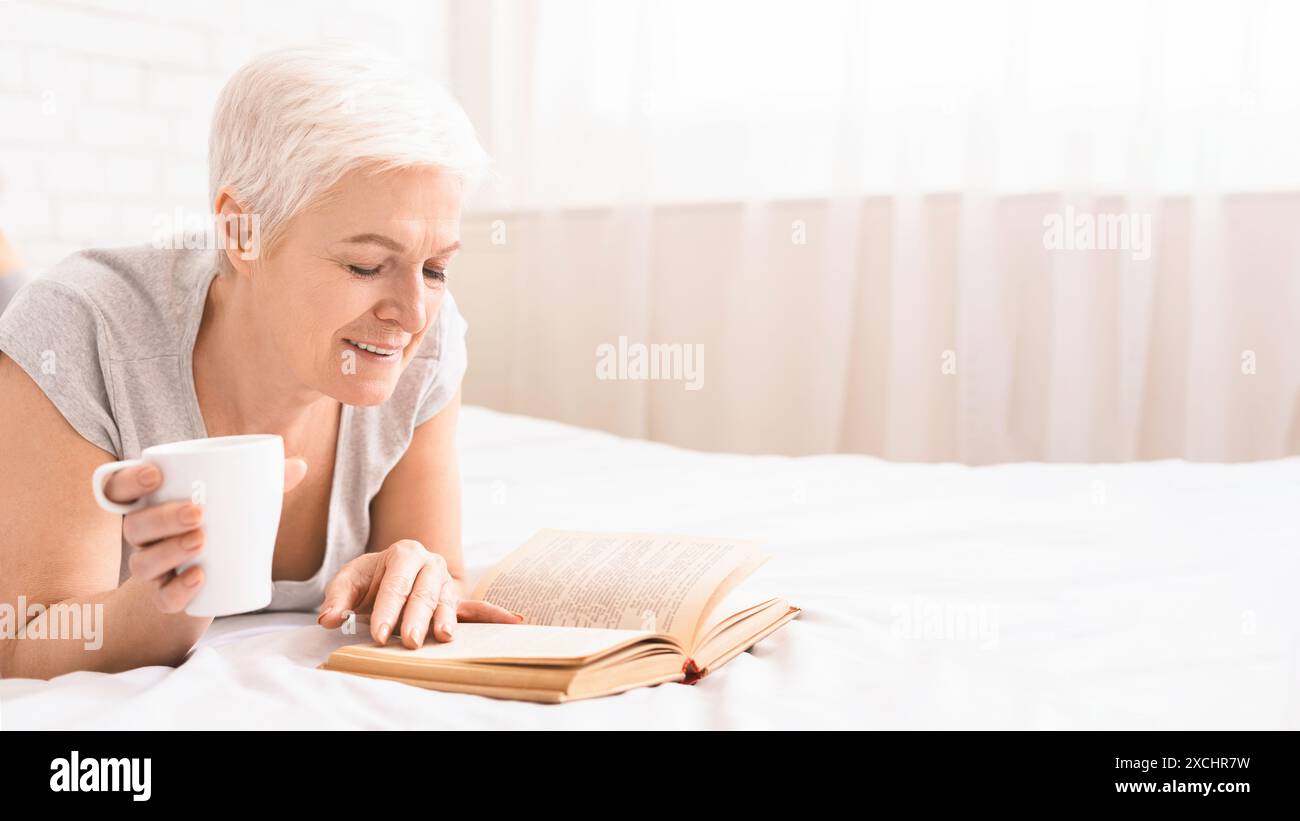 Woman Reading Book and Drinking Coffee on Bed Stock Photo