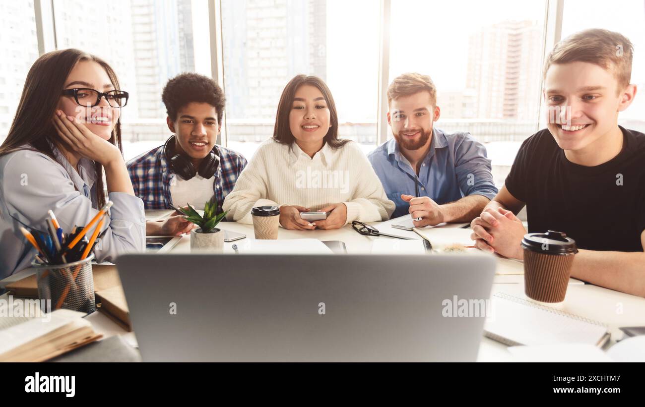 Online lesson. Students learning by laptop in library Stock Photo