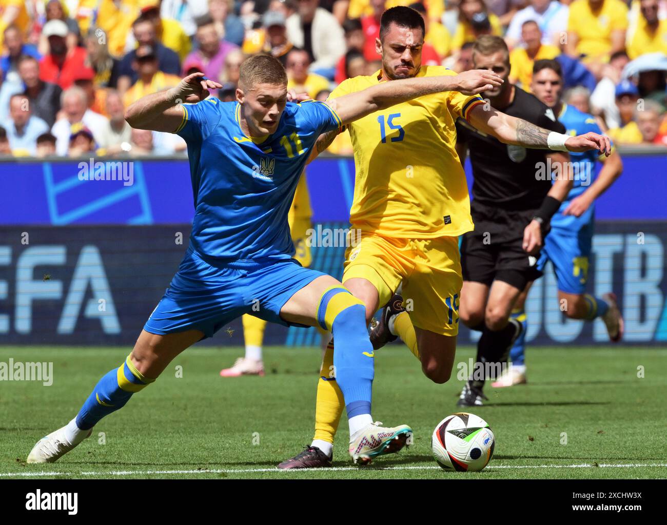 Munich, Germany. 17th June, 2024. Soccer, UEFA Euro 2024, European Championship, Romania - Ukraine, Preliminary round, Group E, Matchday 1, Munich Football Arena, Artem Dowbyk (l) of Ukraine and Romania's Andrei Burca fight for the ball. Credit: Peter Kneffel/dpa/Alamy Live News Stock Photo