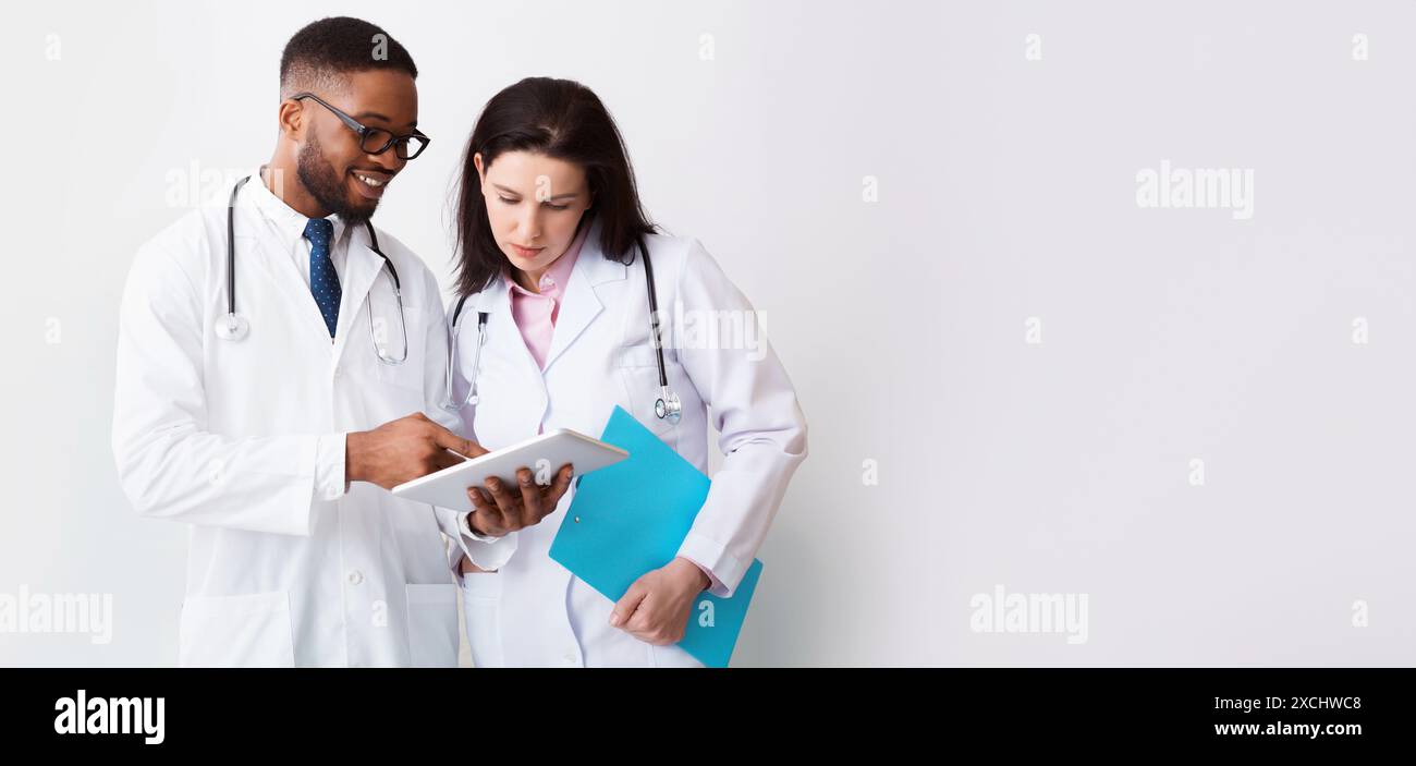Two doctors in white coats discussing diagnosis Stock Photo