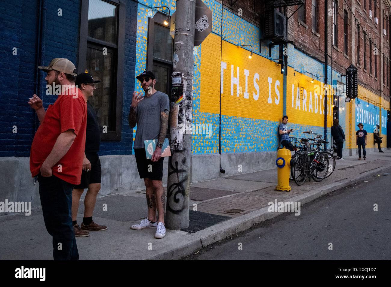 words for smoking a cigarette Man smoking a cigarette in front of a yellow and blue wall bearing the words  THIS IS PARADISE in Toronto, Canada s economic capital in the province of  Stock Photo