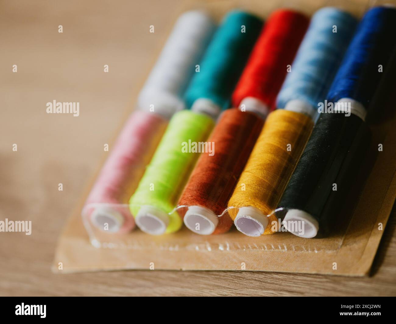 Multicolored sewing threads on paper bobbins and spools in blister packs. Threads for needlework, hobbies and recreation. Necessary item for every fam Stock Photo