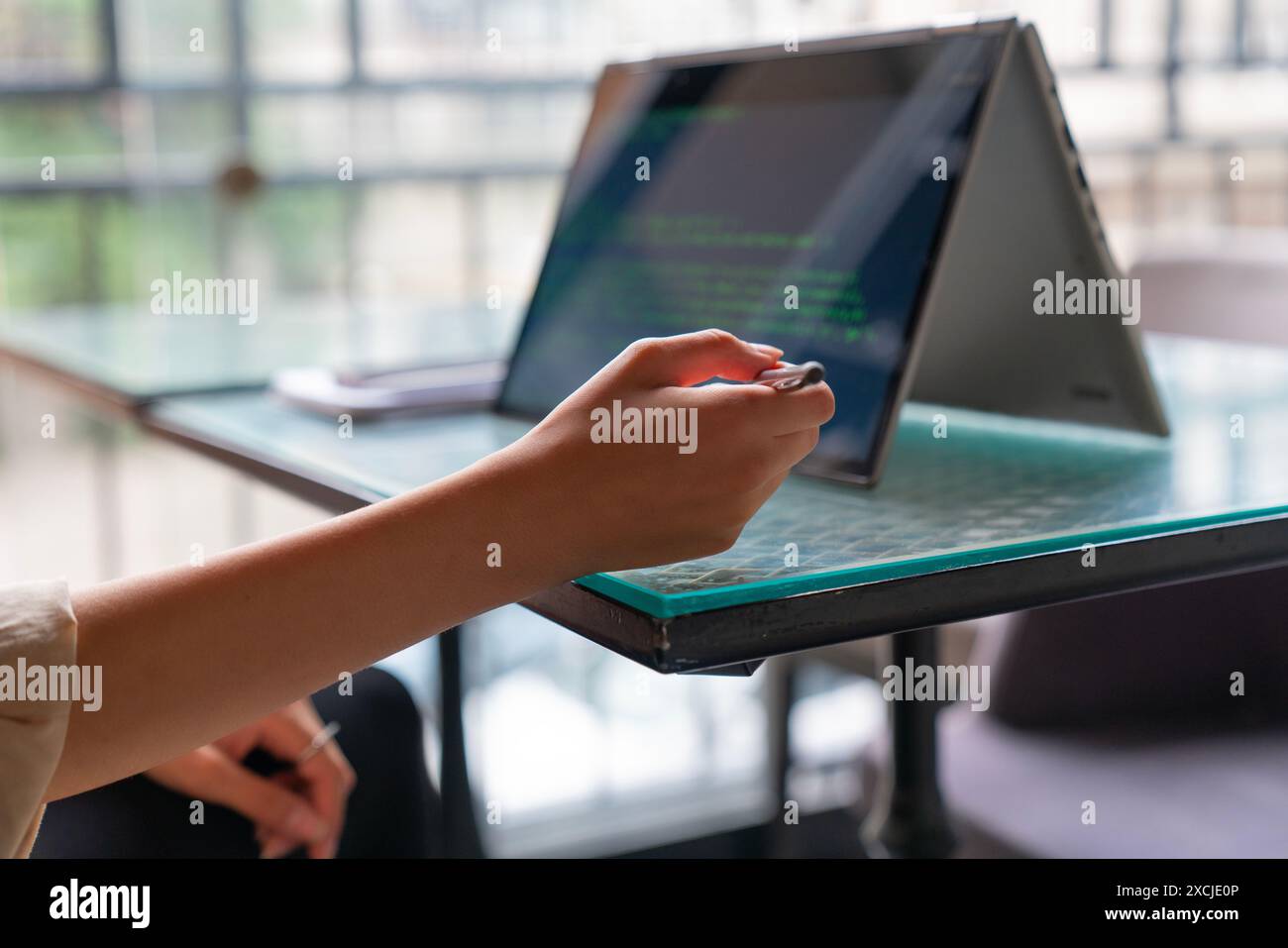 Female freelance developer coding and programming. Coding on two with screens with code language and application. Stock Photo