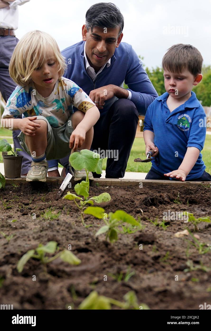 Prime Minister Rishi Sunak helps children with gardening during a visit