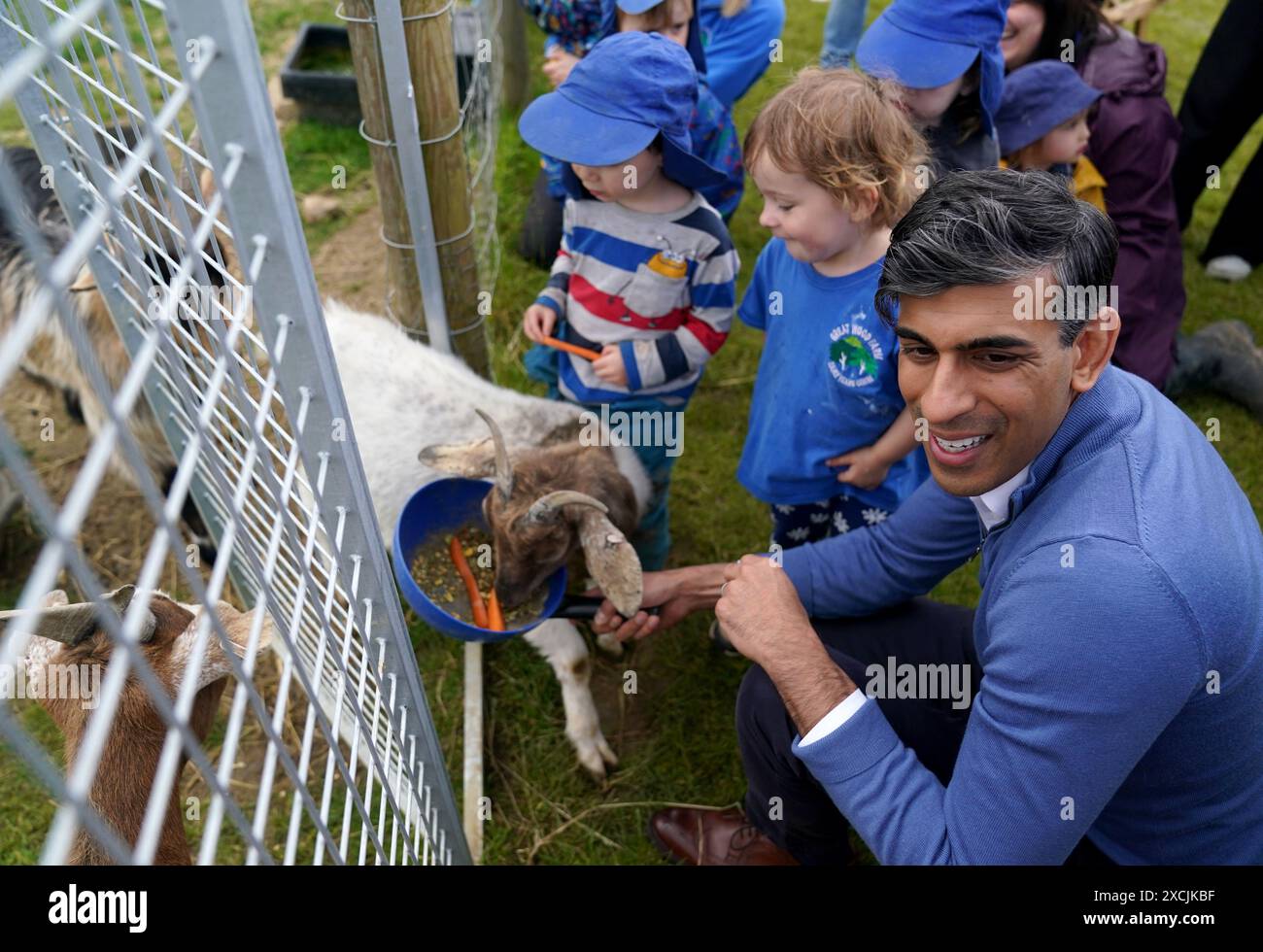 Prime Minister Rishi Sunak helps the children feed the goats during a