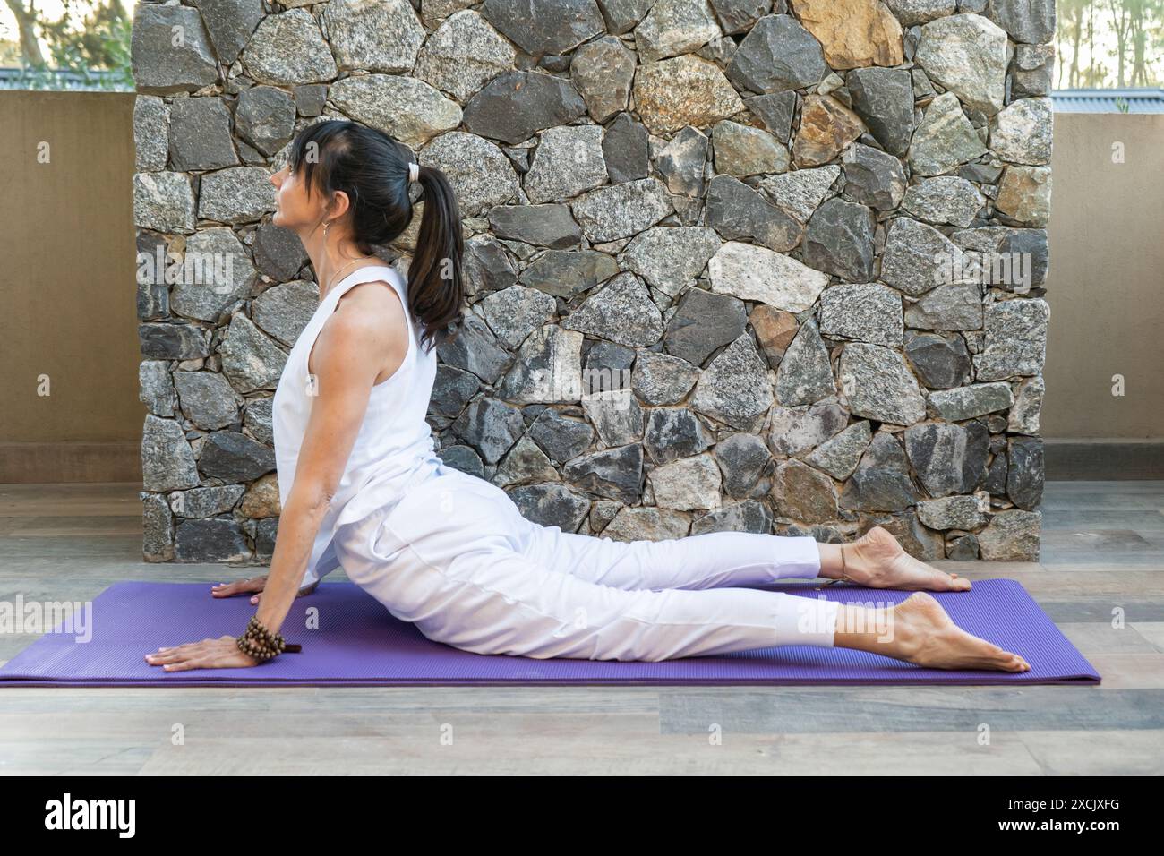 Side view of a woman practicing yoga, doing Cobra pose (Bhujangasana ...