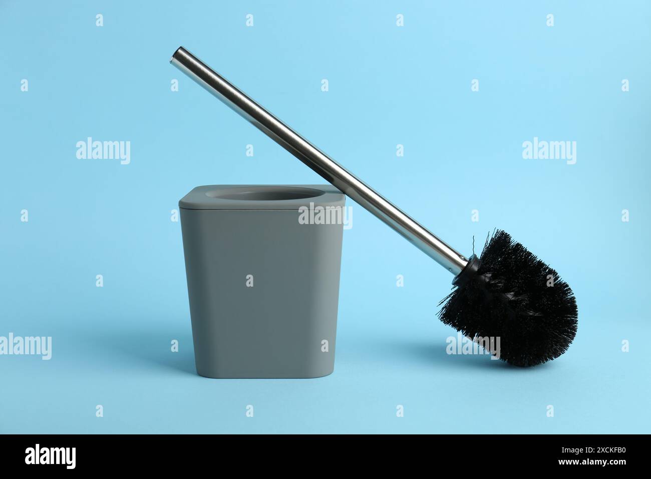 Toilet brush and holder on light blue background Stock Photo - Alamy