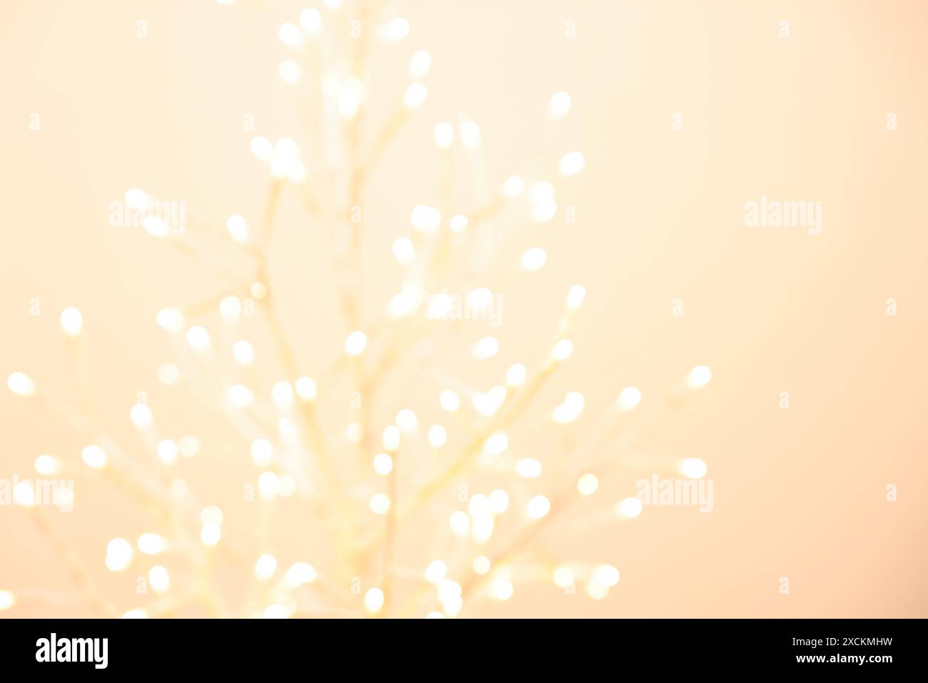 Decorative tree with lights on beige background, blurred view Stock ...