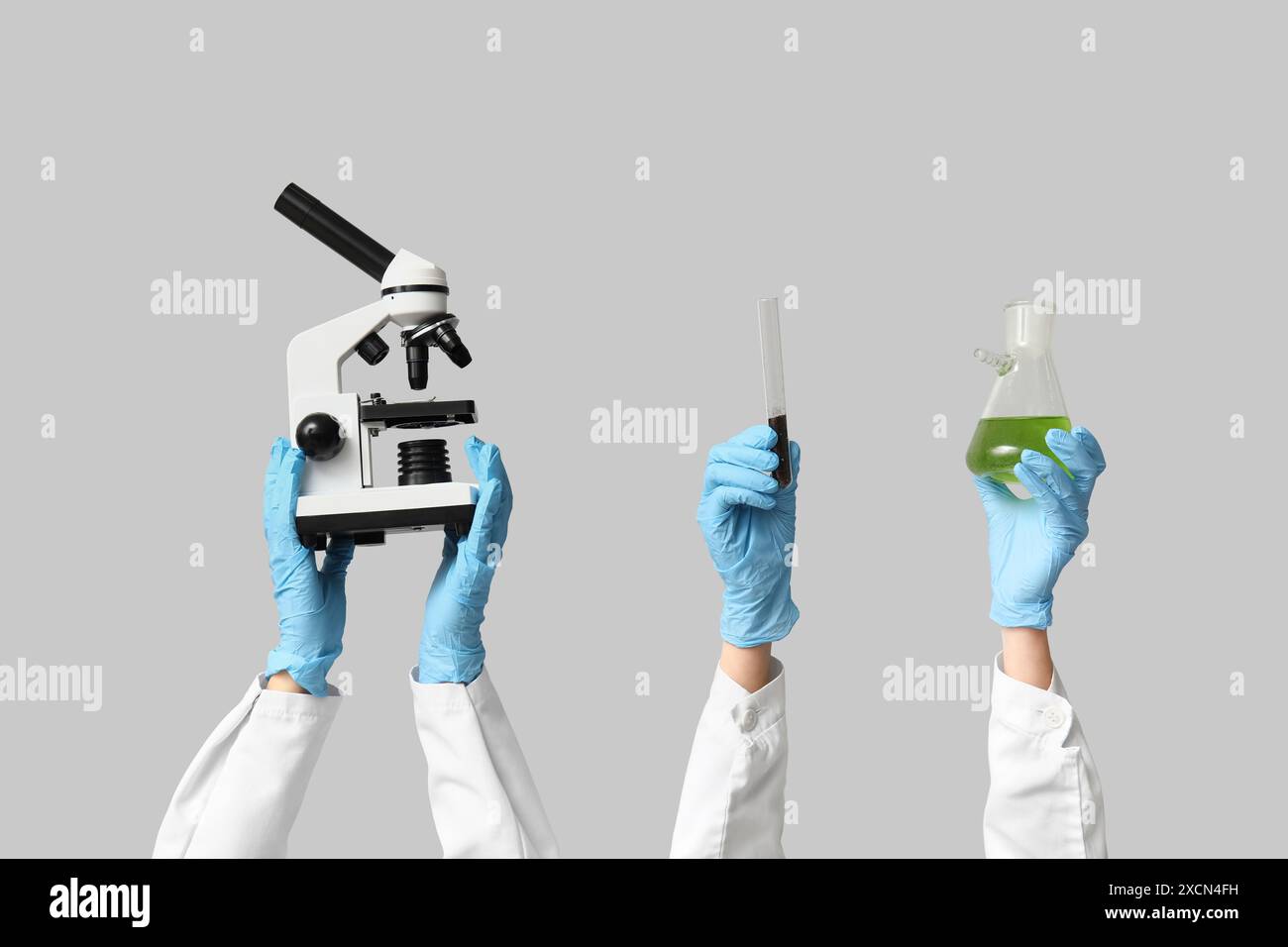 Scientist's hands holding microscope, test tubes with soil and green ...