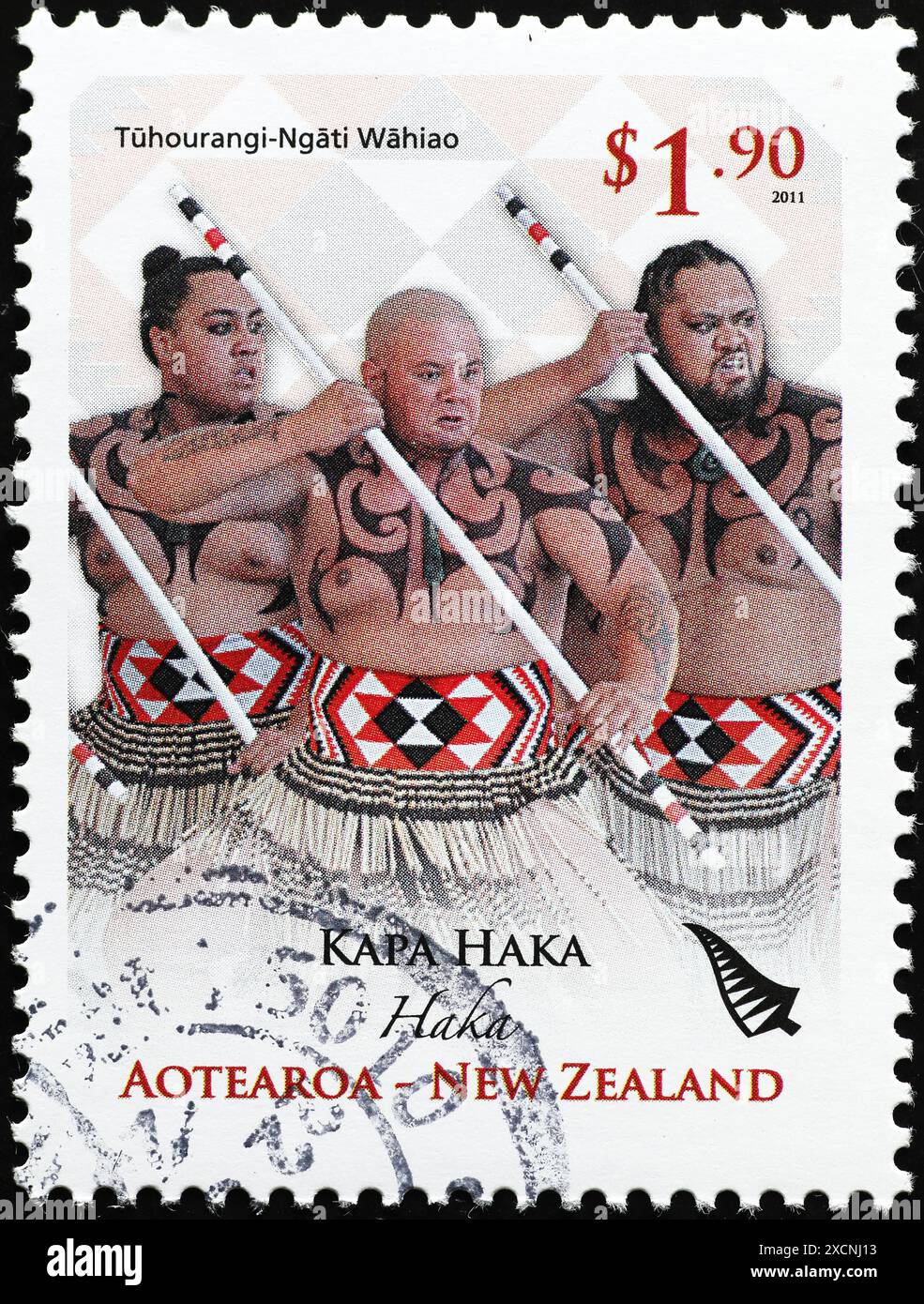 Three maori natives dancing a haka on postage stamp Stock Photo