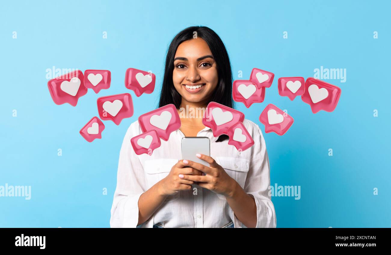 Indian lady texting on her smartphone on blue studio background Stock ...