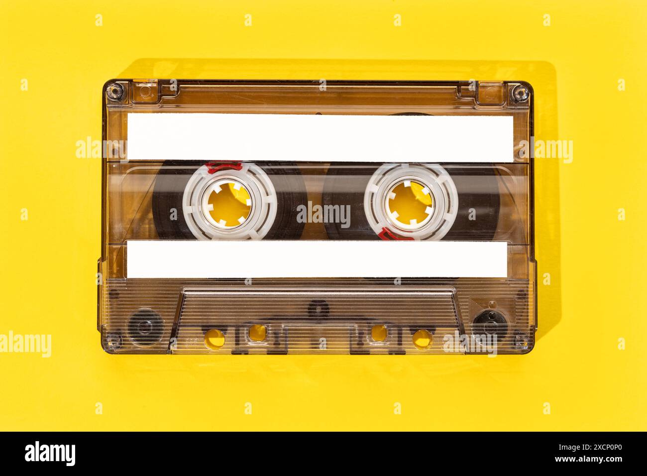 Old tape cassette with blank labels isolated on yellow background, Template mock up Stock Photo