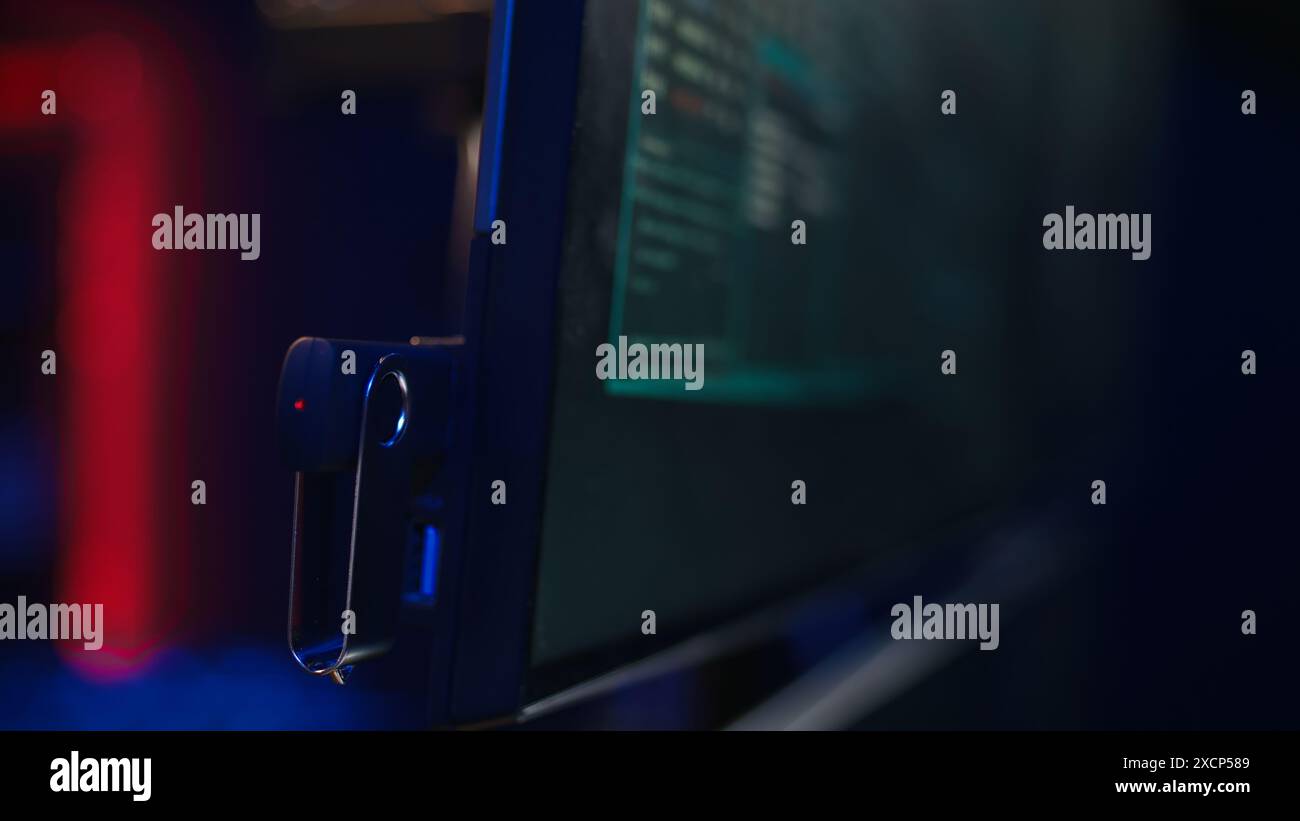 Hacker inserting USB in computer after managing to steal sensitive data, close up. Scammer uploading storage drive into PC after obtaining sensitive information from users using malware, camera B Stock Photo