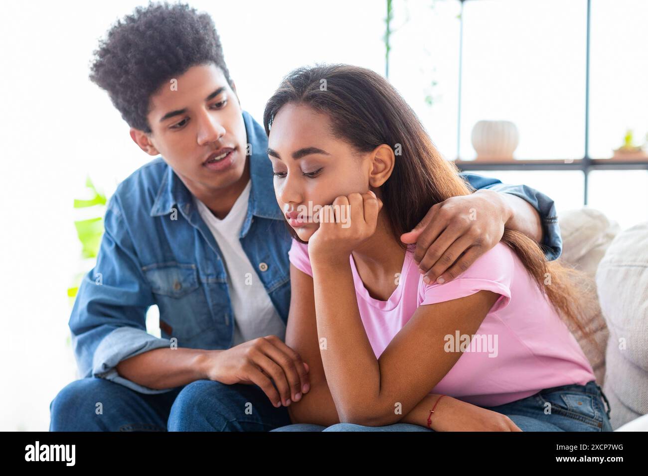 Teen Guy Comforting Sad Girl Sitting on Couch Stock Photo - Alamy