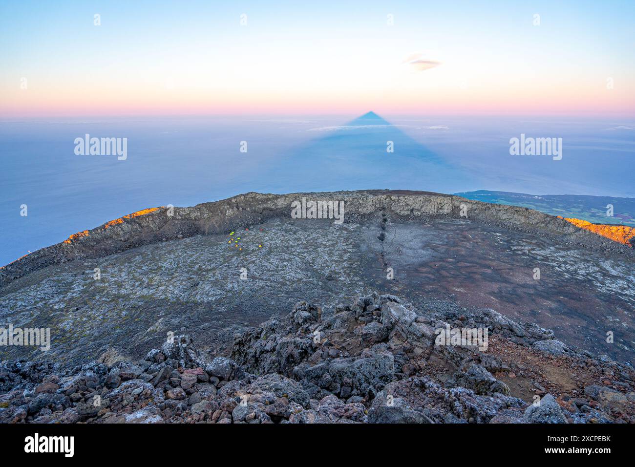 Highest mountain in Portugal, Pico island in the Azores archipelago. Volcano crater with camping tents. projection of the shadow of the mountain on th Stock Photo