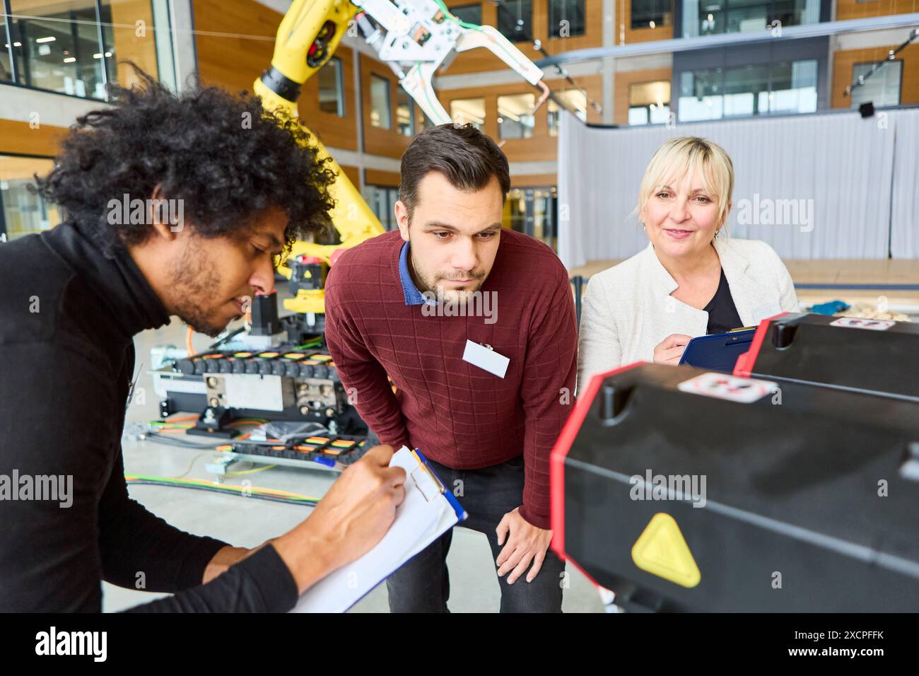 Engineers working together on robotics development and programming in a ...