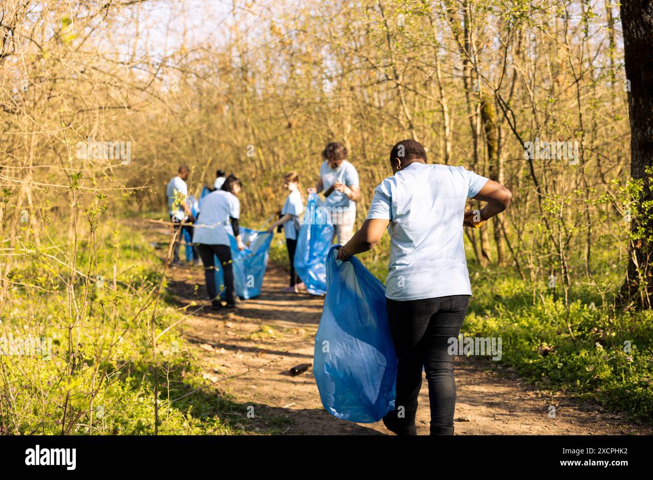 African american woman grabbing junk and plastic waste from the forest ...
