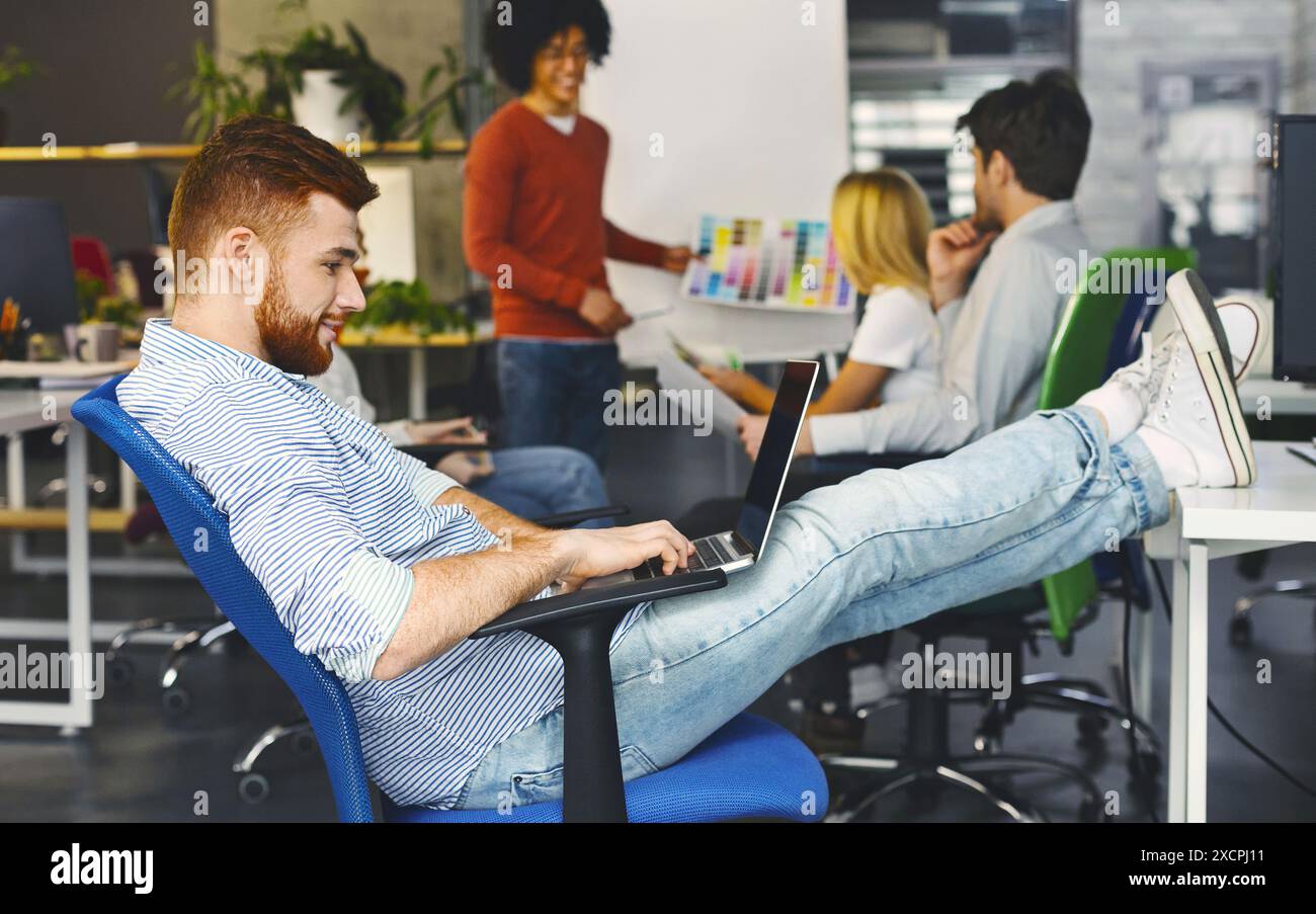 Young Man Working on Laptop in Modern Office Space Stock Photo