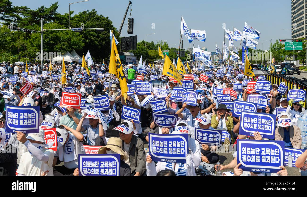 South Korean doctors hold signs protesting the increase in the medical school enrollment rate. The rally coincides with a one-day nationwide strike by local doctors, led by the Korean Medical Association. South Korea's largest lobby group of community doctors on June 18 threatened to begin an indefinite walkout starting June 27 unless the government accepts its demands, including revisiting the issue of increasing medical school admissions. Lim Hyun-taek, head of the Korea Medical Association, made the remarks at a rally of some 10,000 doctors earlier in the day, when some community doctors st Stock Photo