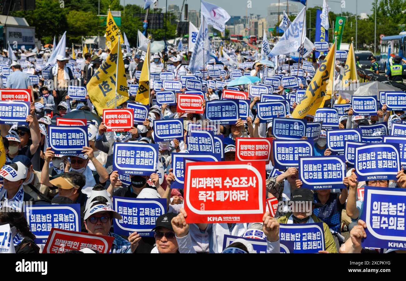South Korean doctors hold signs protesting the increase in the medical school enrollment rate. The rally coincides with a one-day nationwide strike by local doctors, led by the Korean Medical Association. South Korea's largest lobby group of community doctors on June 18 threatened to begin an indefinite walkout starting June 27 unless the government accepts its demands, including revisiting the issue of increasing medical school admissions. Lim Hyun-taek, head of the Korea Medical Association, made the remarks at a rally of some 10,000 doctors earlier in the day, when some community doctors st Stock Photo