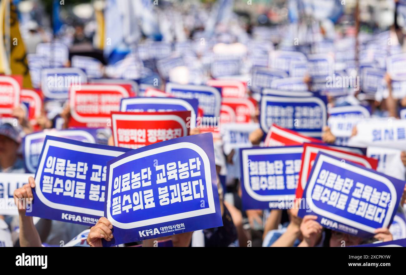 South Korean doctors hold signs protesting the increase in the medical school enrollment rate. The rally coincides with a one-day nationwide strike by local doctors, led by the Korean Medical Association. South Korea's largest lobby group of community doctors on June 18 threatened to begin an indefinite walkout starting June 27 unless the government accepts its demands, including revisiting the issue of increasing medical school admissions. Lim Hyun-taek, head of the Korea Medical Association, made the remarks at a rally of some 10,000 doctors earlier in the day, when some community doctors st Stock Photo