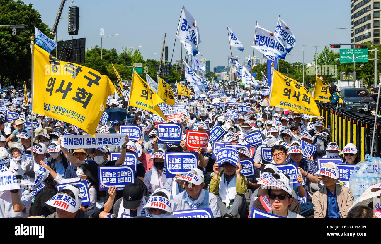 South Korean doctors hold signs protesting the increase in the medical school enrollment rate. The rally coincides with a one-day nationwide strike by local doctors, led by the Korean Medical Association. South Korea's largest lobby group of community doctors on June 18 threatened to begin an indefinite walkout starting June 27 unless the government accepts its demands, including revisiting the issue of increasing medical school admissions. Lim Hyun-taek, head of the Korea Medical Association, made the remarks at a rally of some 10,000 doctors earlier in the day, when some community doctors st Stock Photo