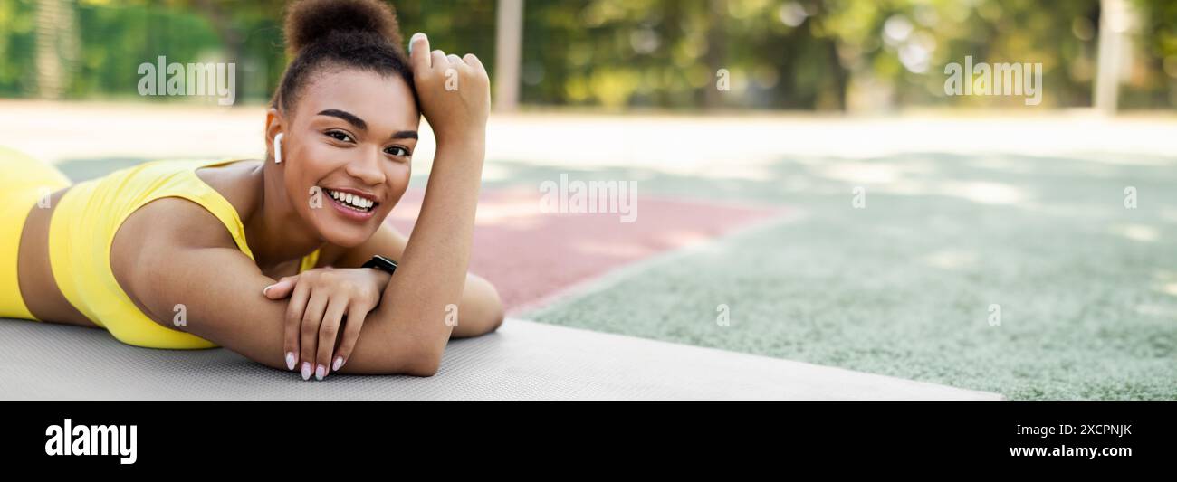 Sporty black woman in yellow sportswear lying and posing Stock Photo ...