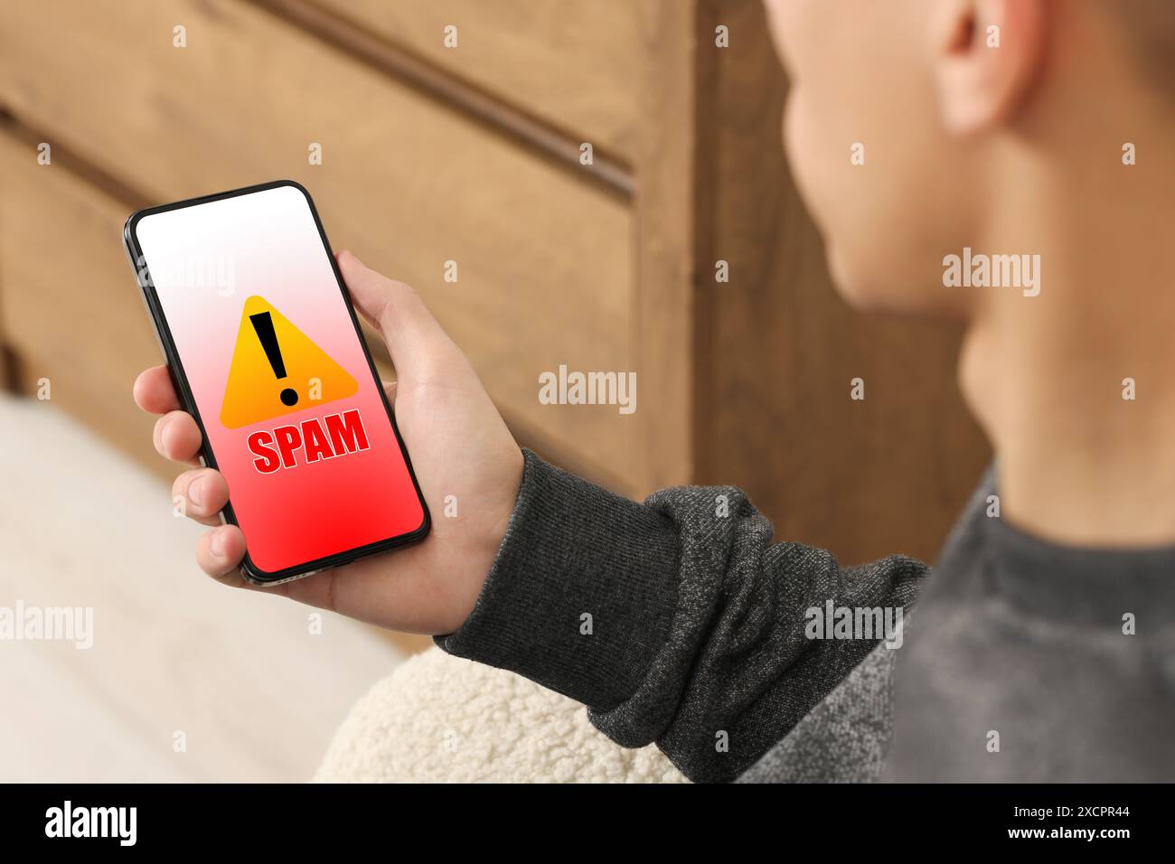 Man using smartphone indoors, closeup. Spam message notification on device screen, illustration Stock Photo