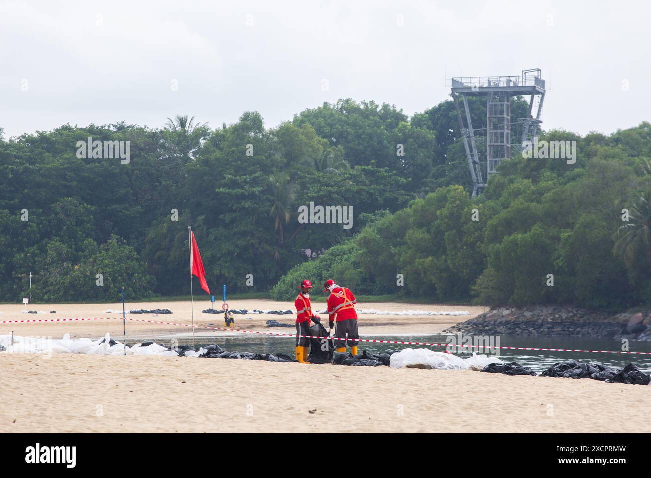 Workers are cleaning up oil spill along Palawan Beach, Sentosa. Singapore Stock Photo Alamy