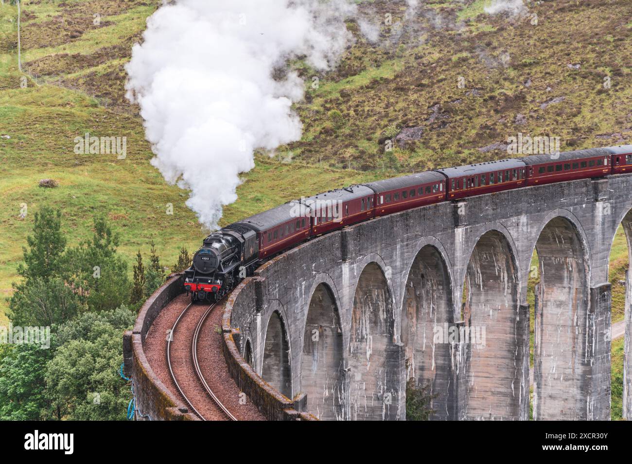 Steam train passing over the viaduct Stock Photo