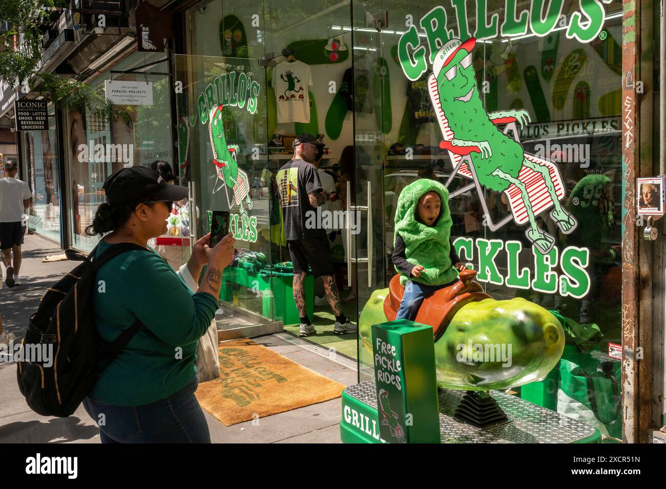 A child dressed as a pickle takes a ride on a pickle at the GrilloÕs