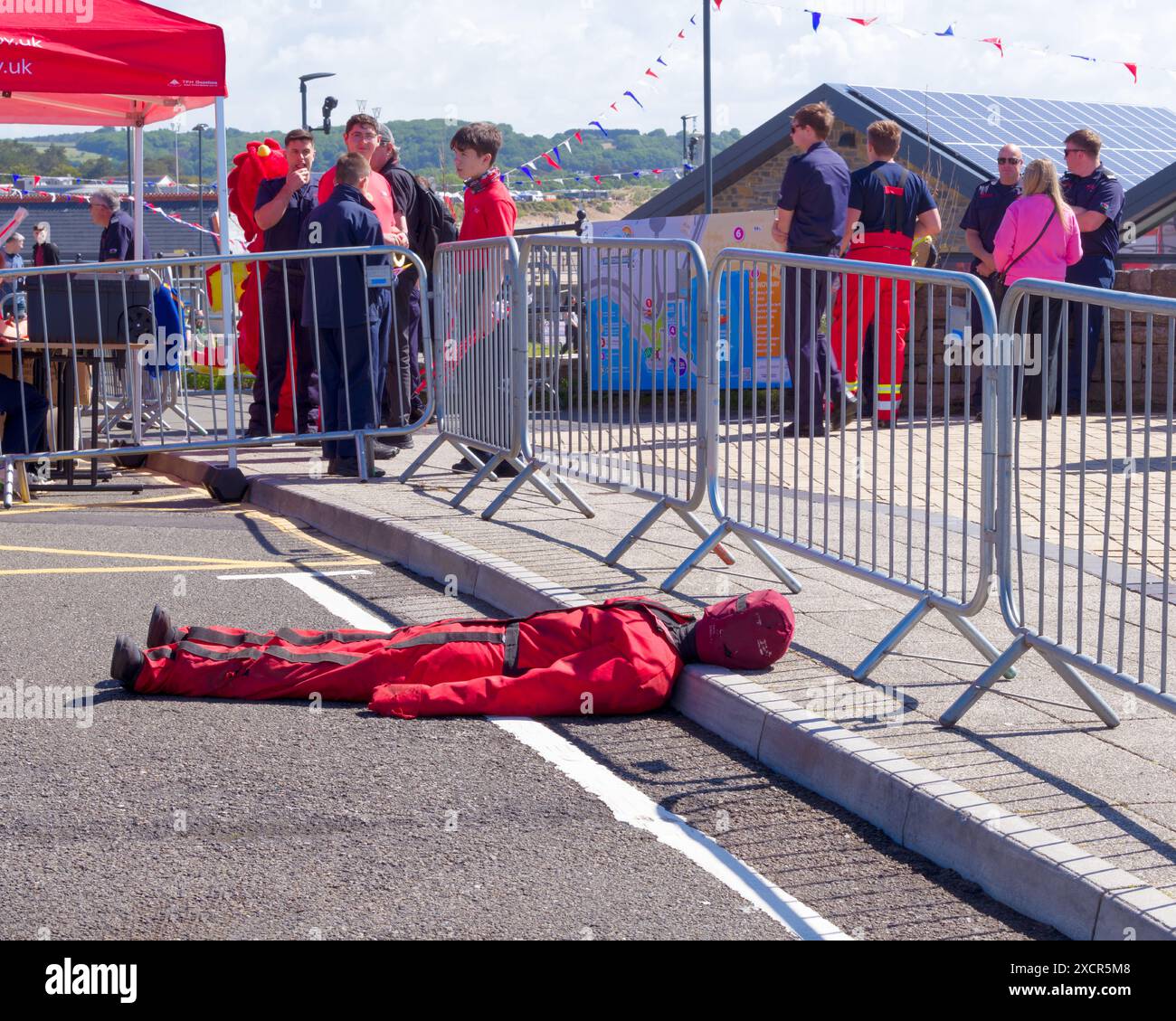 A fire service dummy in a jumpsuit lies on roadside at a mock crash site at Rescue Fest 2024. Cozy Corner, Porthcawl , UK. 16th June 2024. Stock Photo