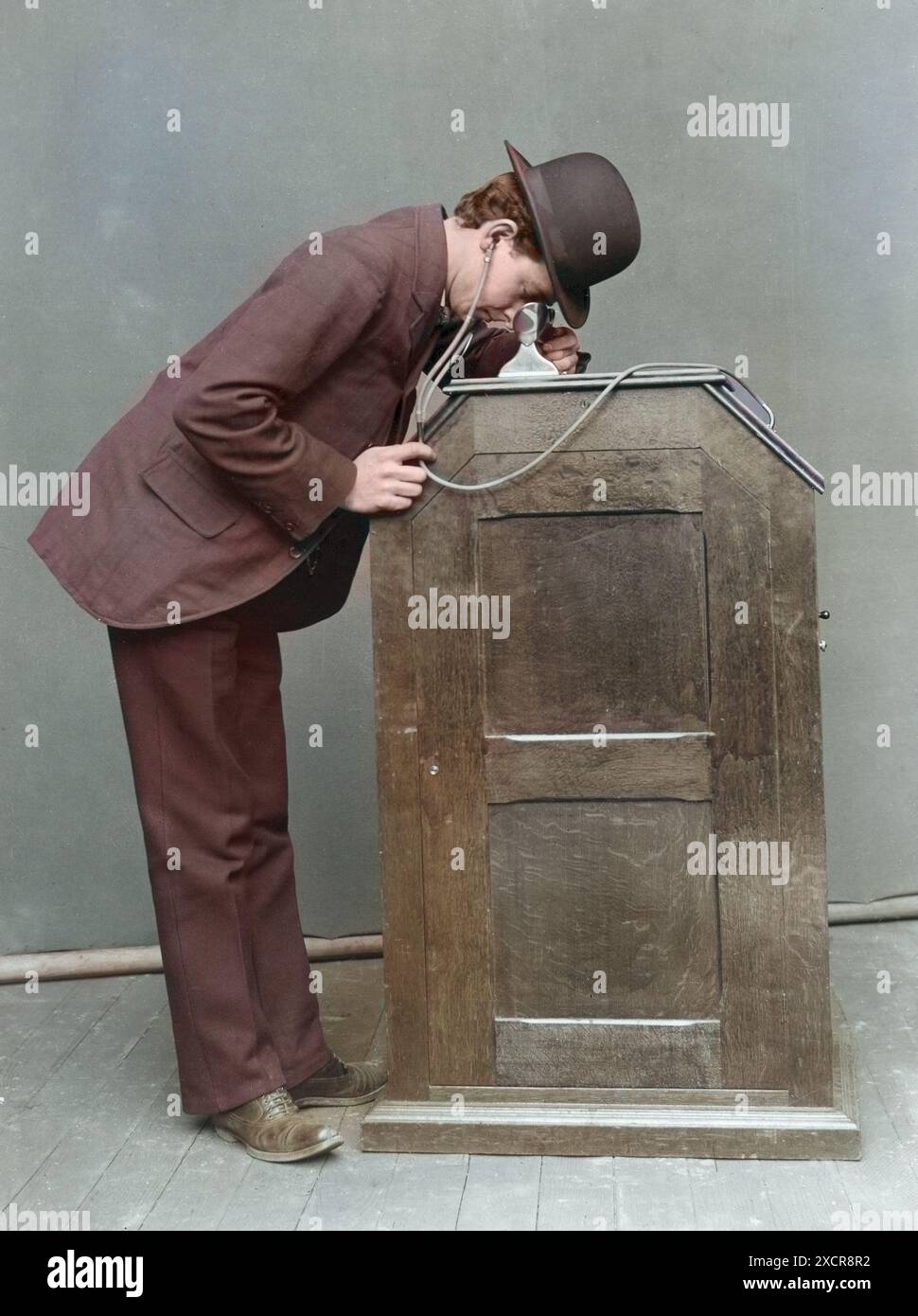 The 1895 version of the Kinetophone in use, showing the earphones that lead to the cylinder phonograph within the cabinet. The Kinetophone (aka Phonok Stock Photo