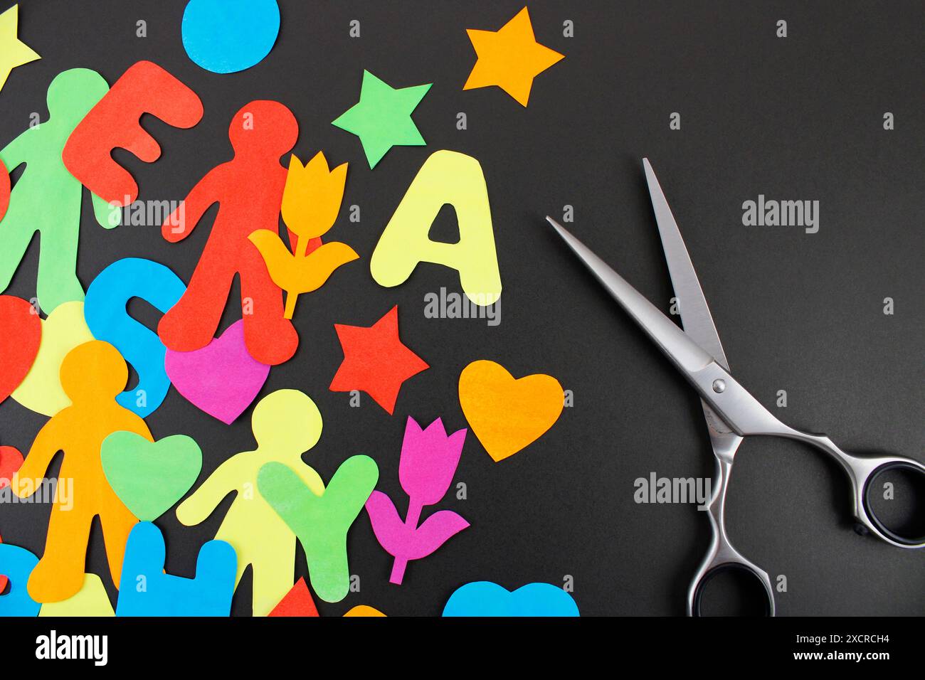 Scissors and cutting paper figures with various shapes and colors Stock Photo