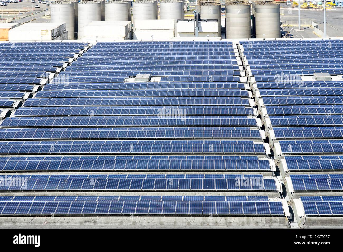 Blue photovoltaic solar panels mounted on large industrial building ...