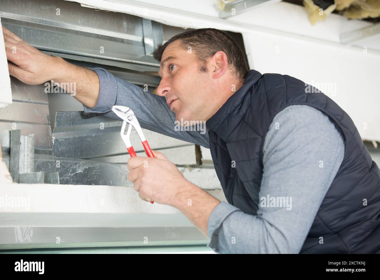 male checking the state of a window frame Stock Photo
