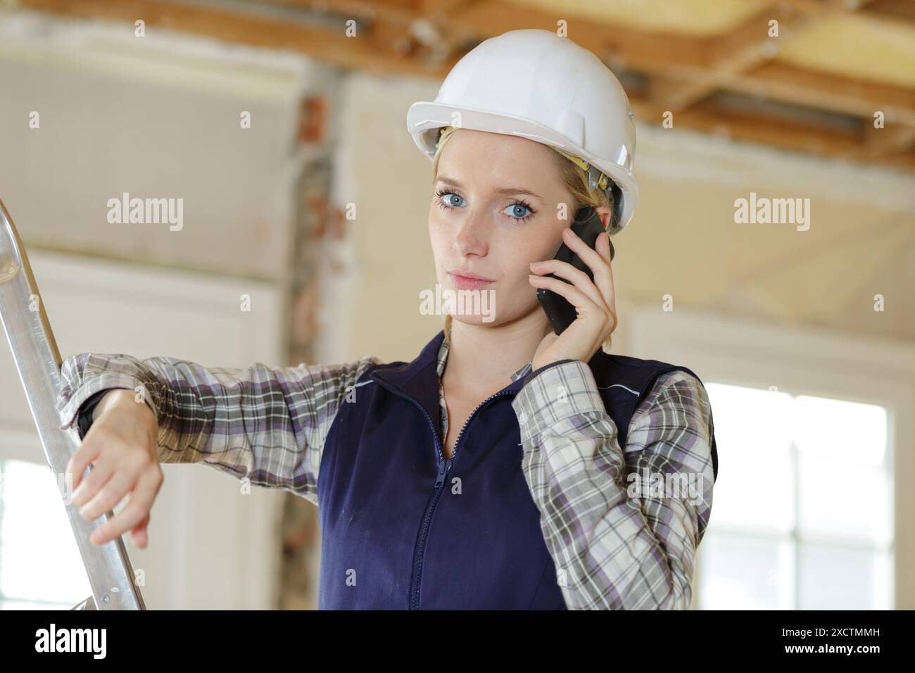 woman builder with blueprints using smart phone Stock Photo