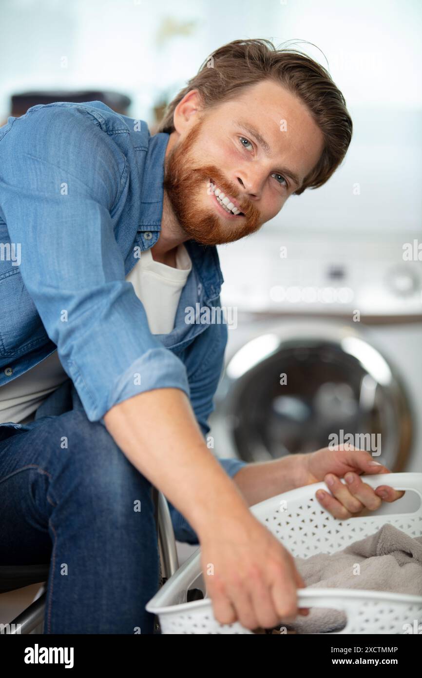 disabled man on wheelchair doing laundry Stock Photo