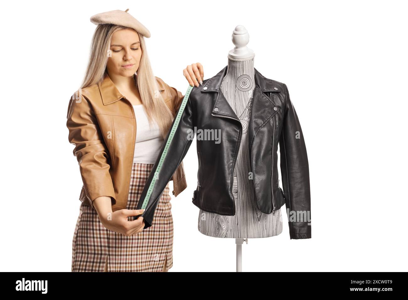 Young female fashion designer measuring a jacket sleeve on a mannequin ...