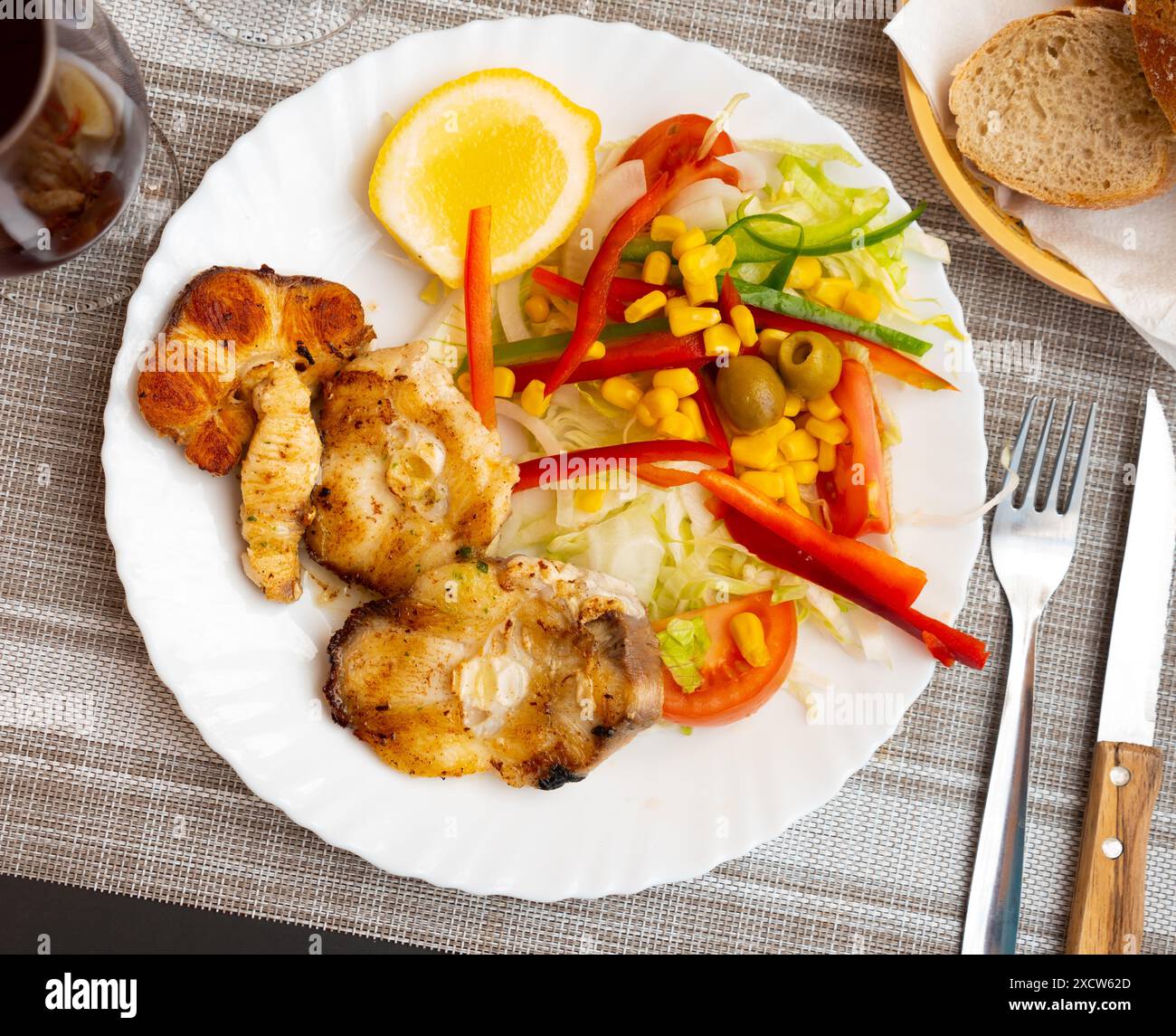 Oven baked hake with vegetable garnish Stock Photo