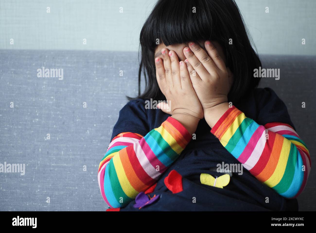 a upset child girl cover her face with hand Stock Photo - Alamy
