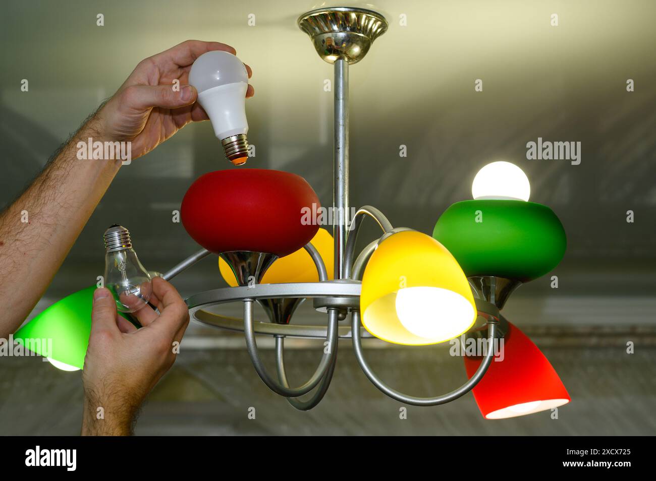 Replacing a lamp in a chandelier. concept Stock Photo